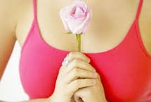 woman's bust pink top holding rose